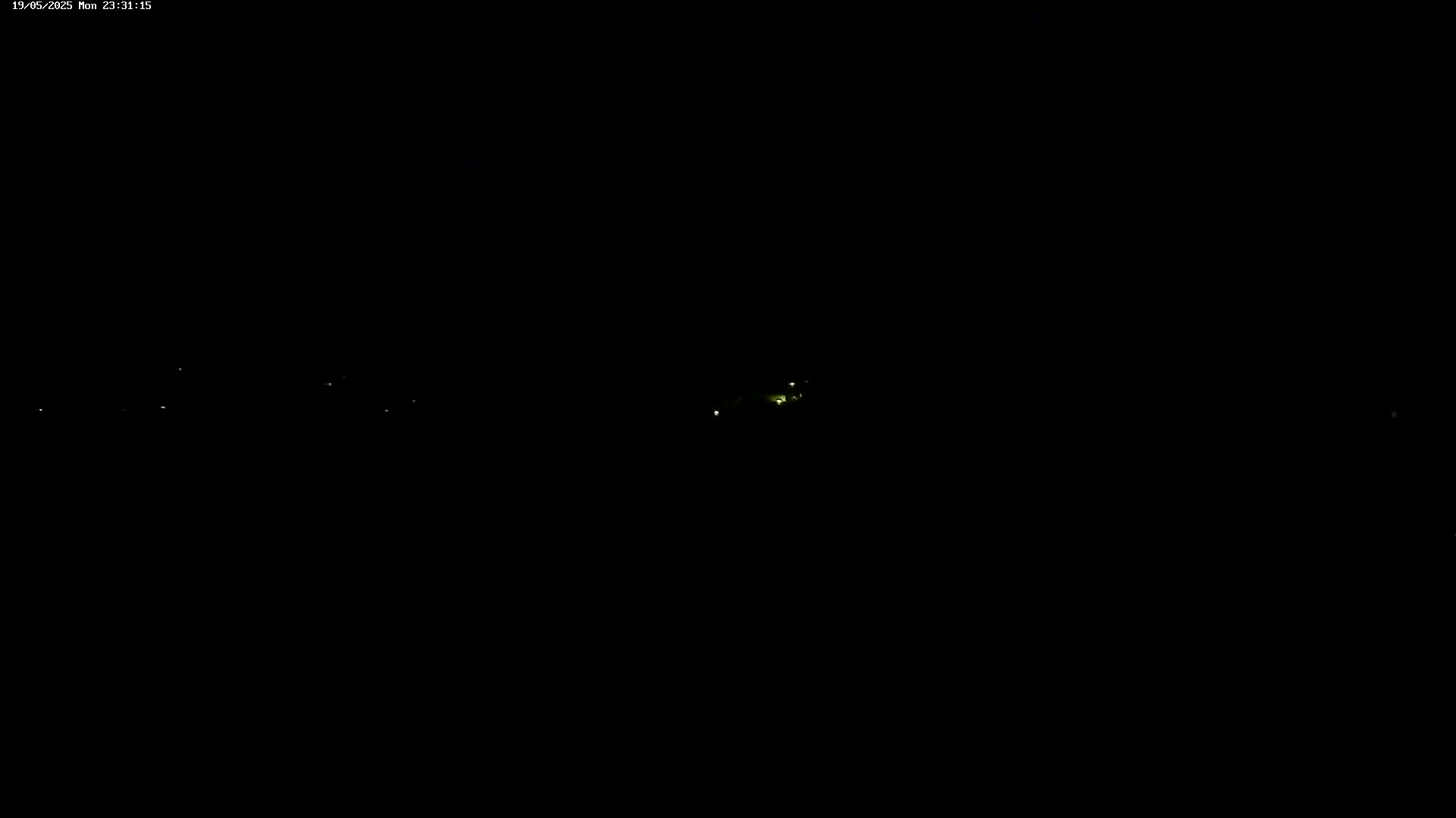 A dark, nighttime scene shows a few distant, faint lights.