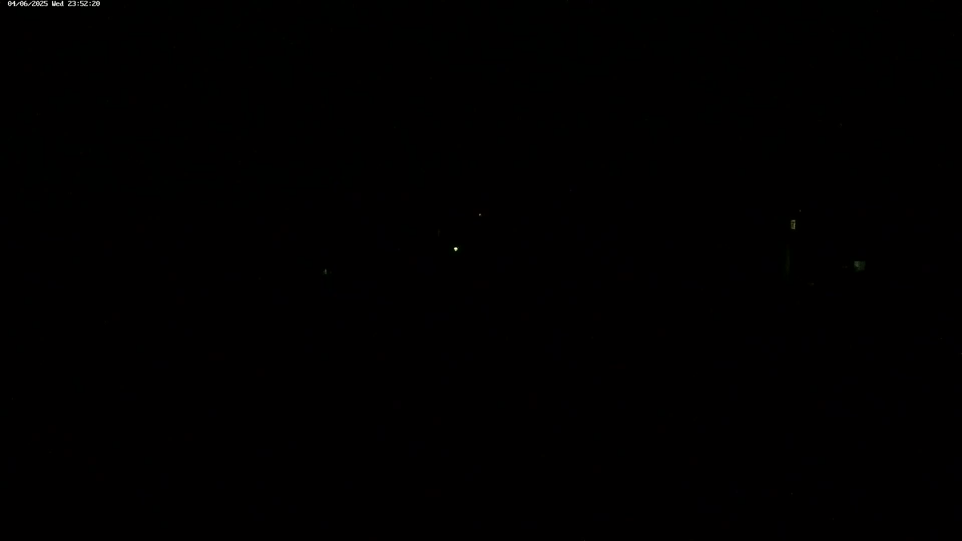 A dark, nighttime scene with a few faint, distant lights visible.