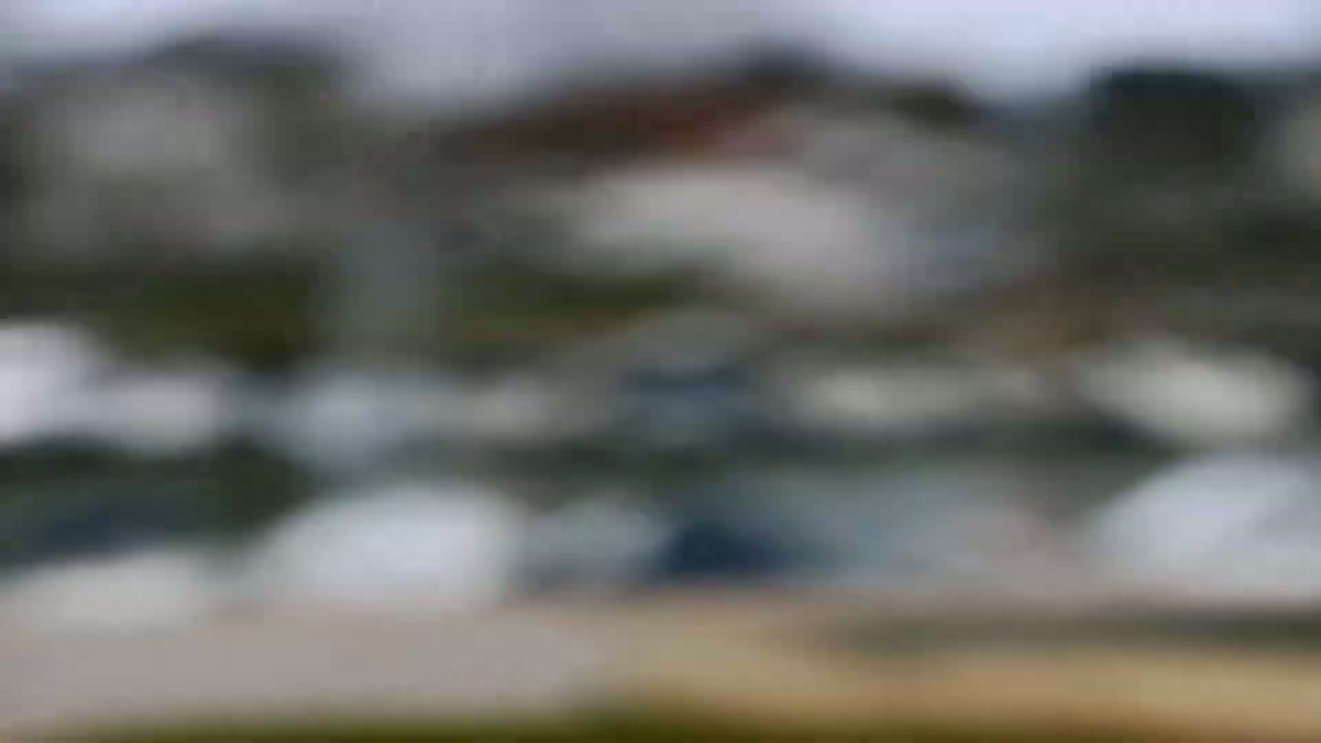 A blurry image shows an out-of-focus view of a cluster of buildings on an overcast day.