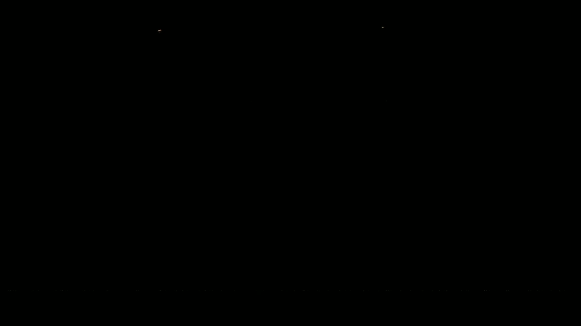 The image is entirely black except for a few tiny specks of light.