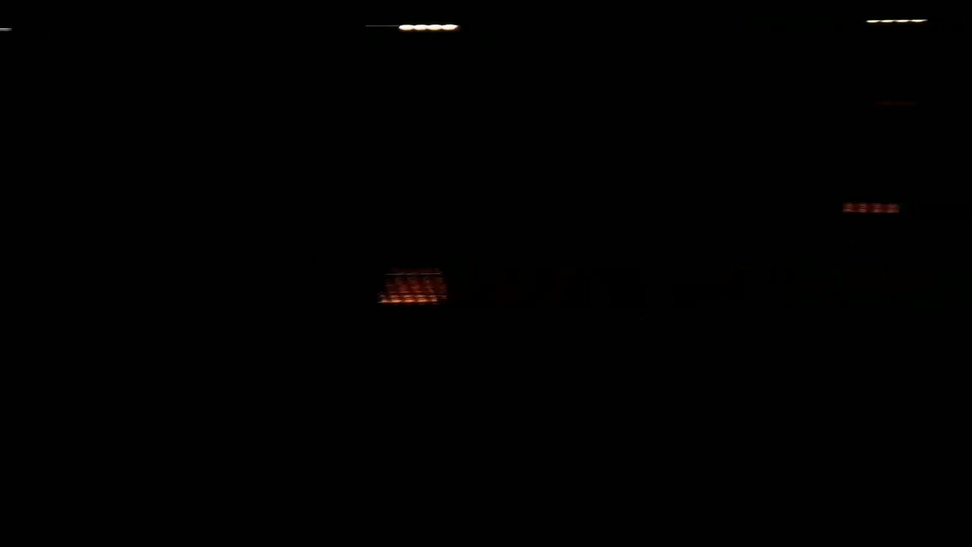 A mostly dark scene shows several small, blurry lights at varying distances.