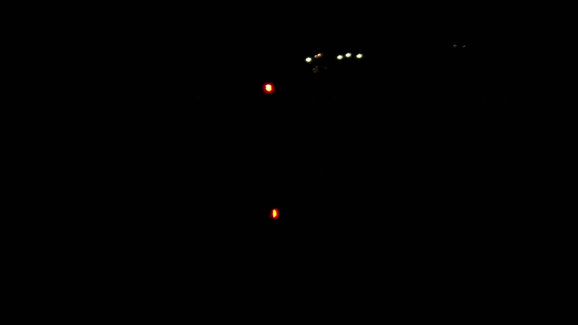 Several small, distant lights are visible in the dark night.