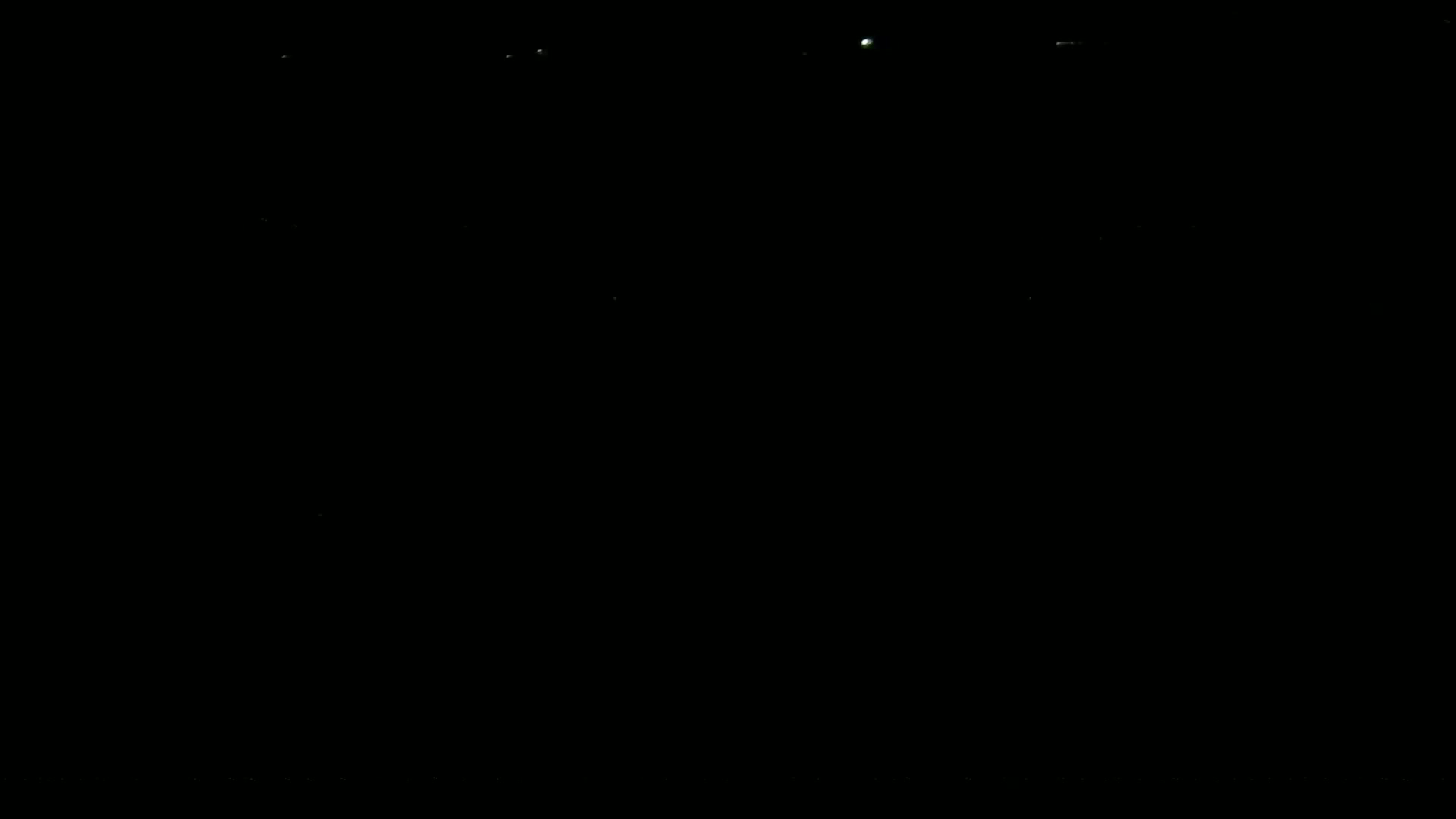 The image shows a completely black background with a few tiny specks of light.