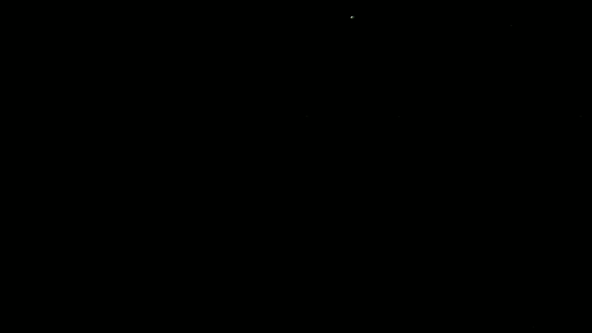 The image is a completely black screen with a few very faint, almost invisible specks of light.