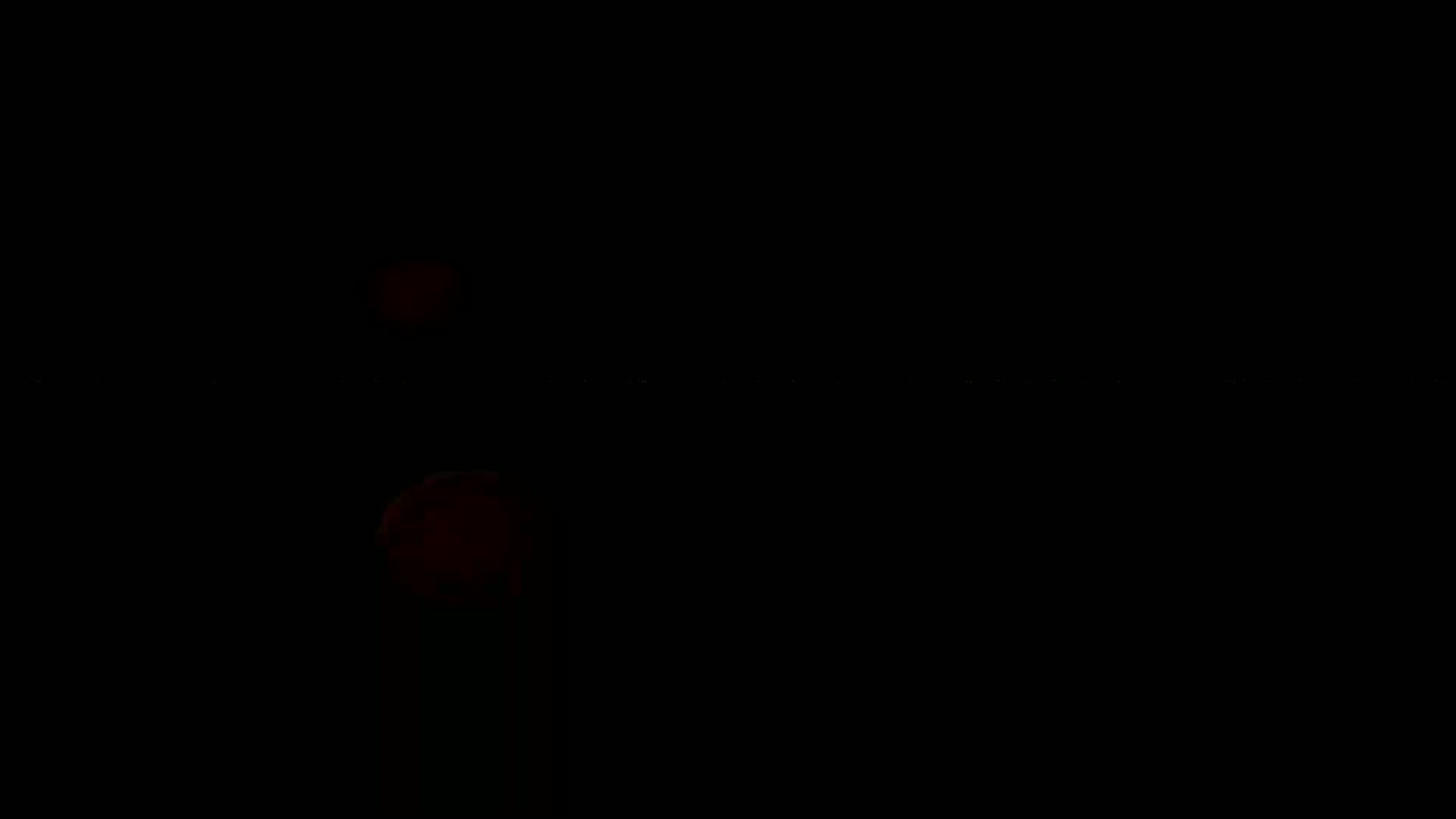 Two blurry, red, circular lights are visible in the dark.