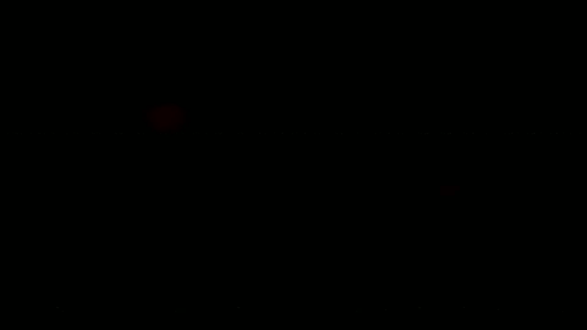 A blurry, dark image shows a faint reddish light in the center.