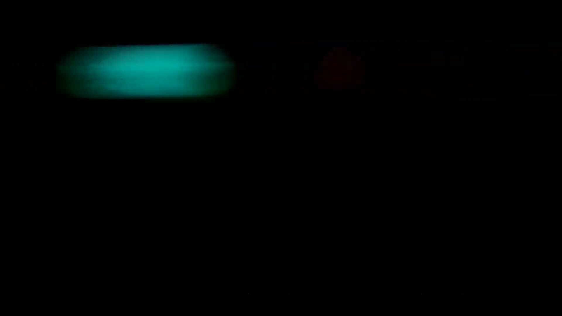 A blurry, teal light streaks across a mostly black background.