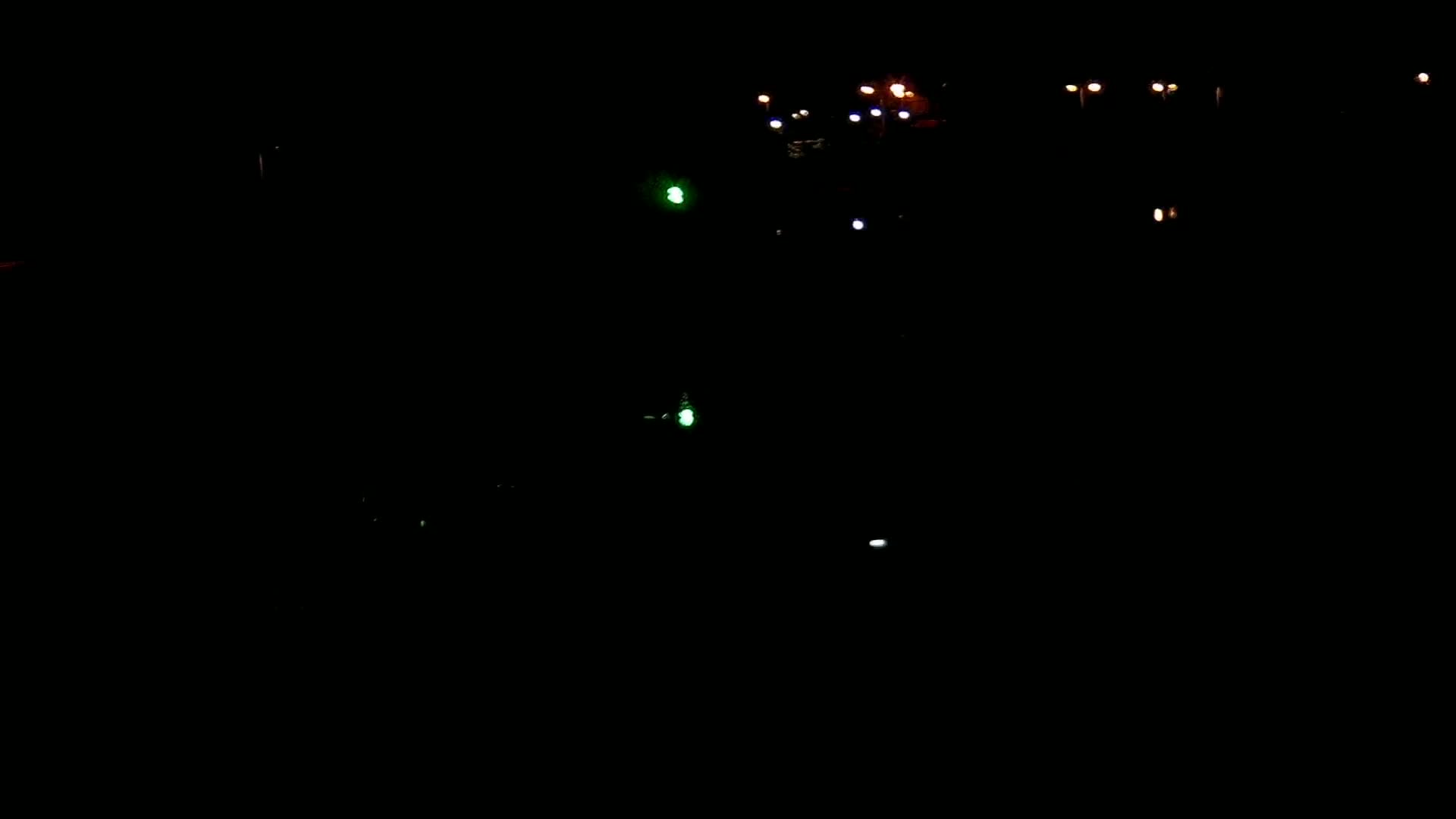 A nighttime scene shows scattered lights in the darkness.