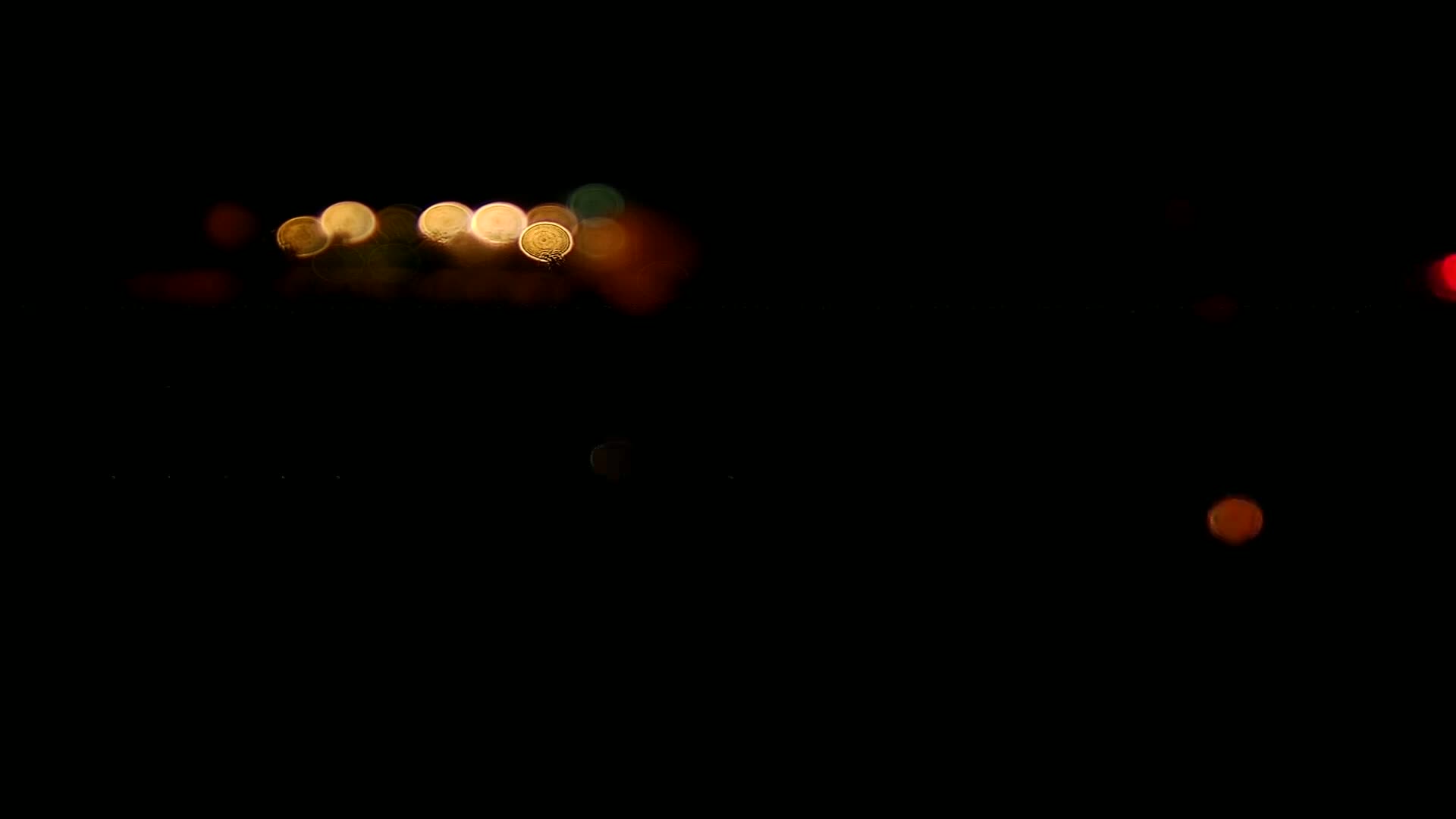 Out-of-focus lights of varying colors are visible in the darkness of night.