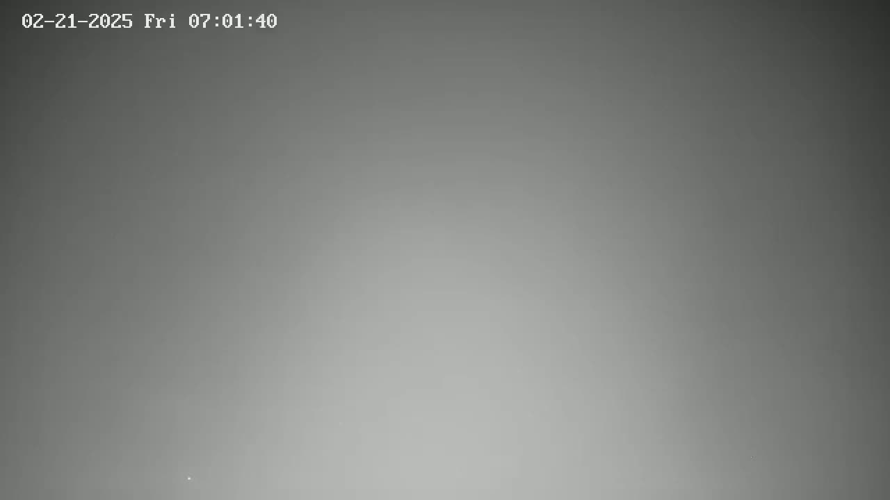 A blurry, gray image shows an overcast sky.