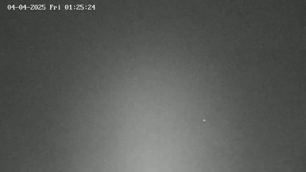 A dark, possibly nighttime, sky shows a single, faint light.