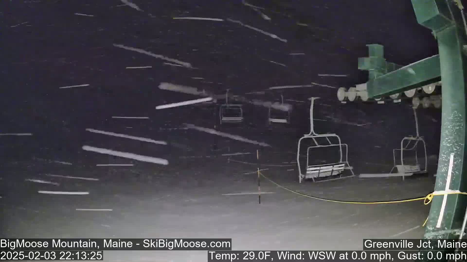 A nighttime scene of a ski lift under heavy snowfall.