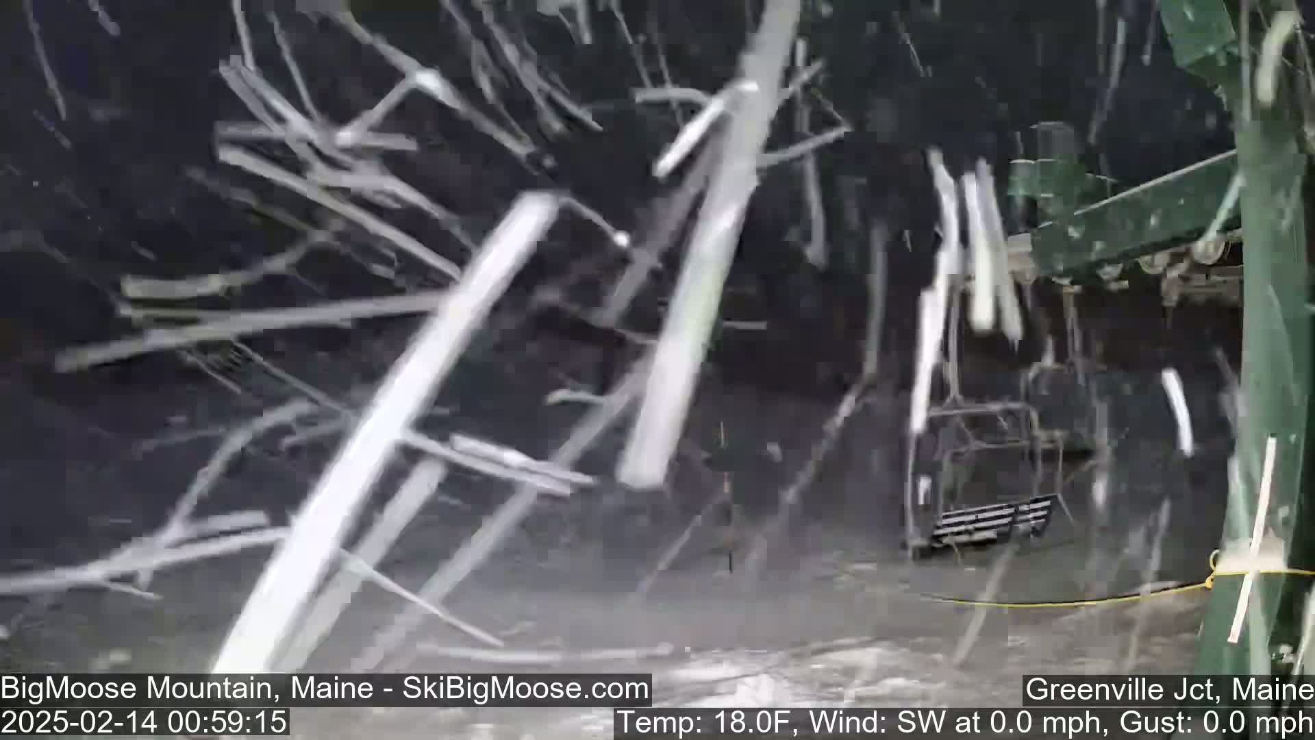 A ski lift chair is visible through heavy snowfall.