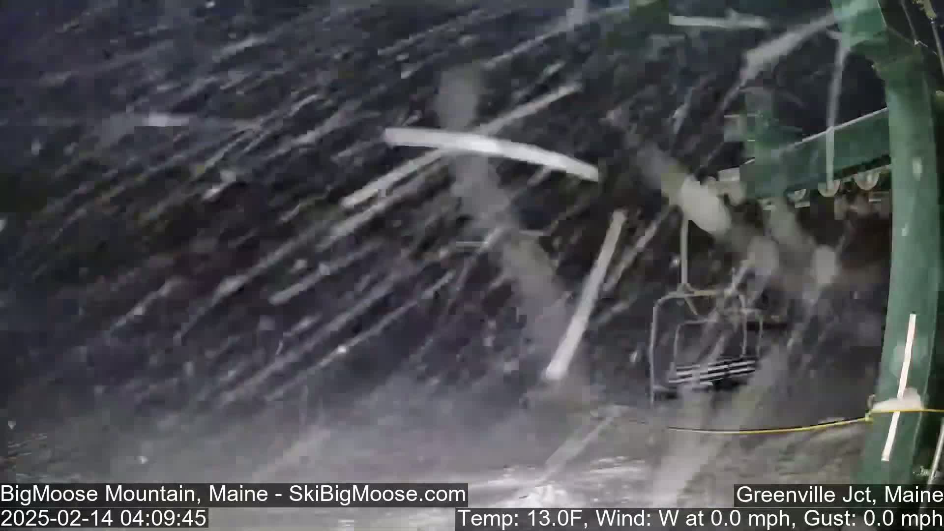 A chairlift moves through heavy snowfall.