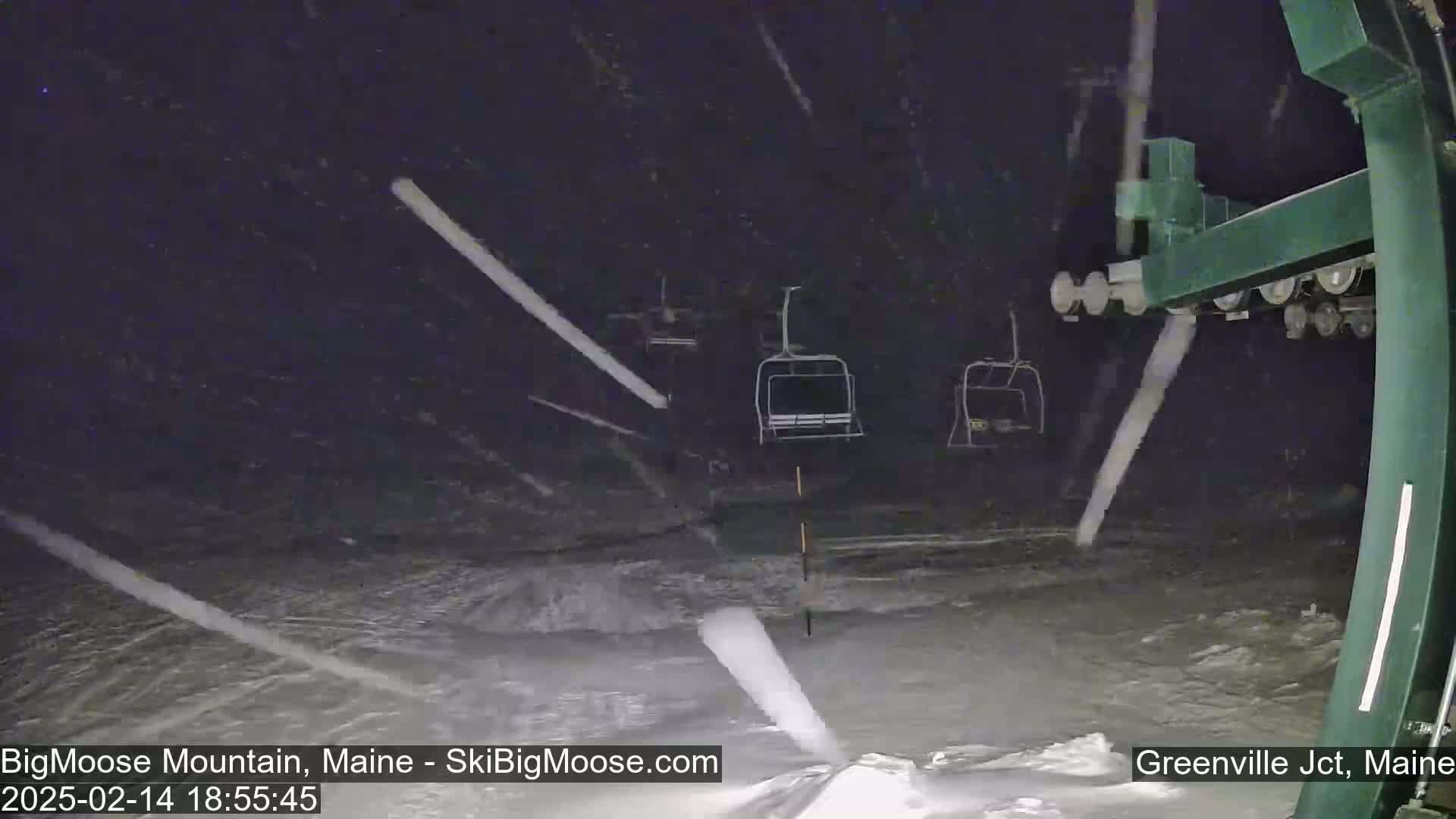 A nighttime view of a ski lift in heavy snowfall.