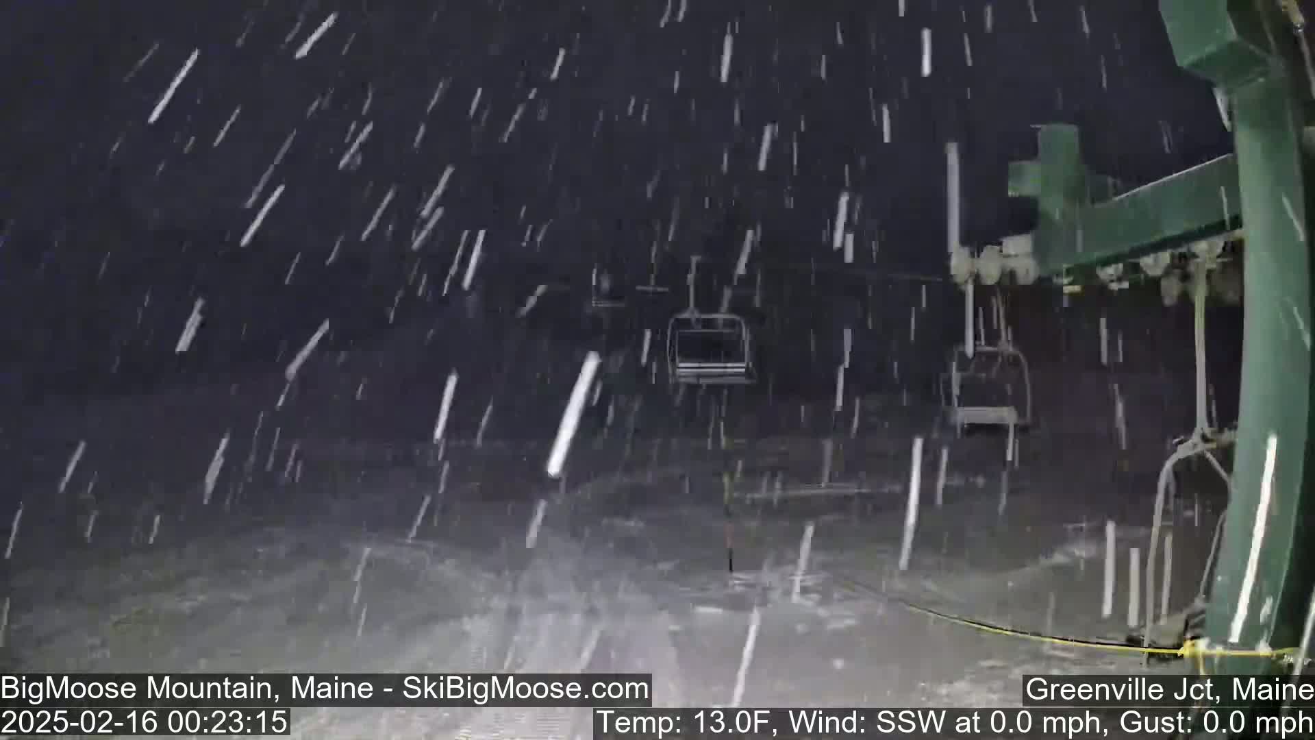 A nighttime view of a ski lift during a heavy snowfall.