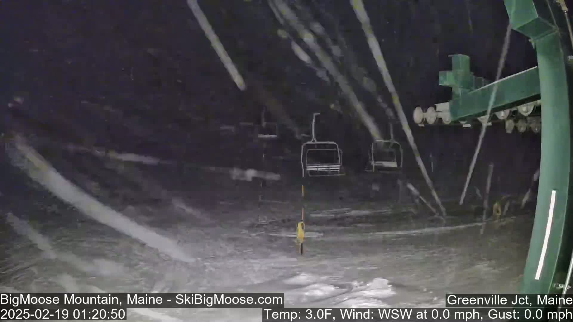A nighttime view of a ski lift during a heavy snowfall.