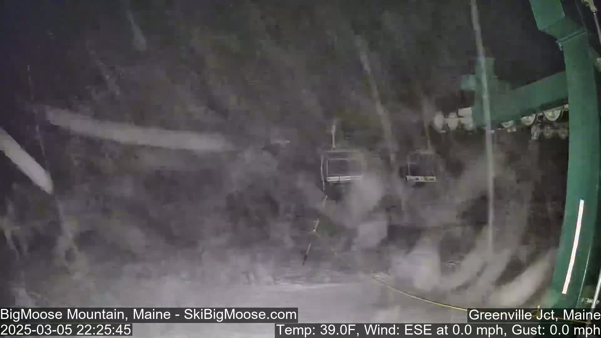 A nighttime view of a ski lift in heavy snow.