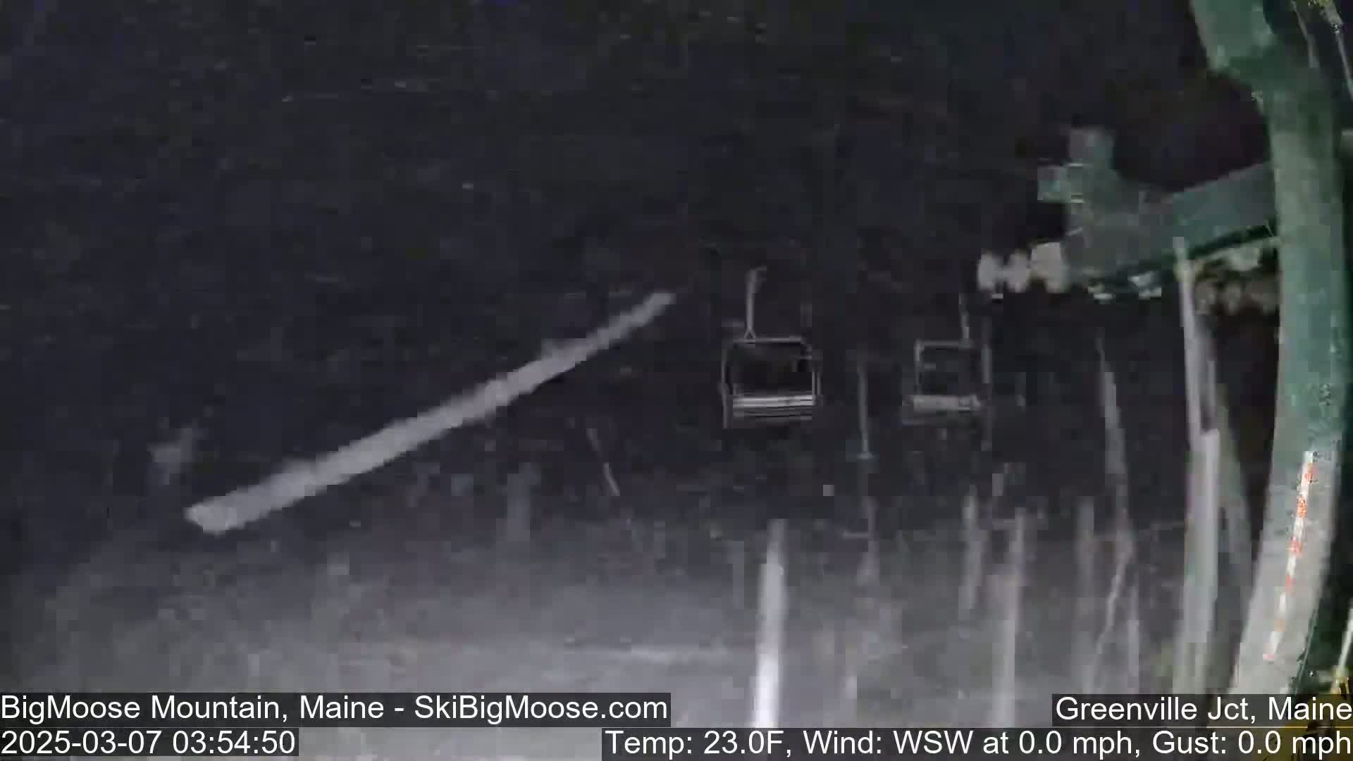 A chairlift ascends through heavy snowfall.