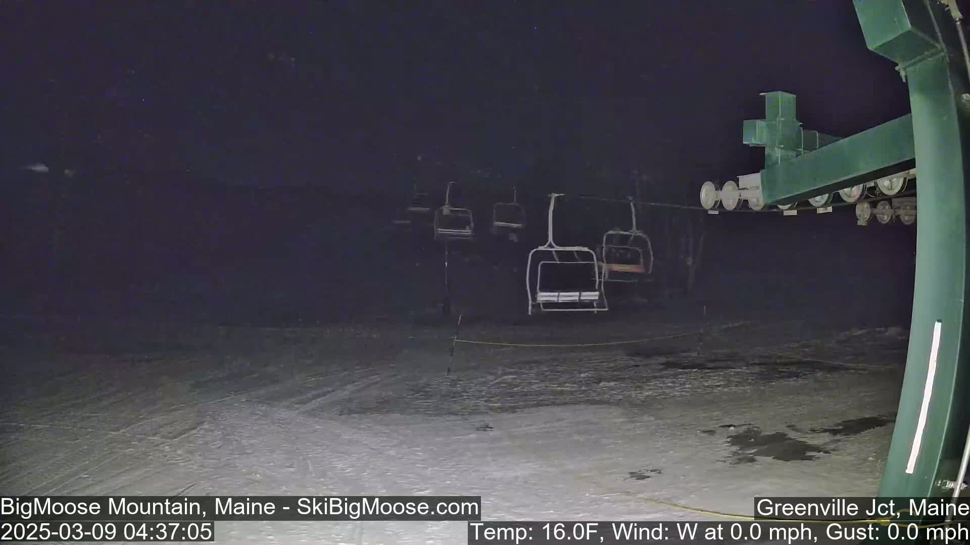 A nighttime view of a ski lift with empty chairlifts and a snow-covered ground at 16 degrees Fahrenheit with no wind.