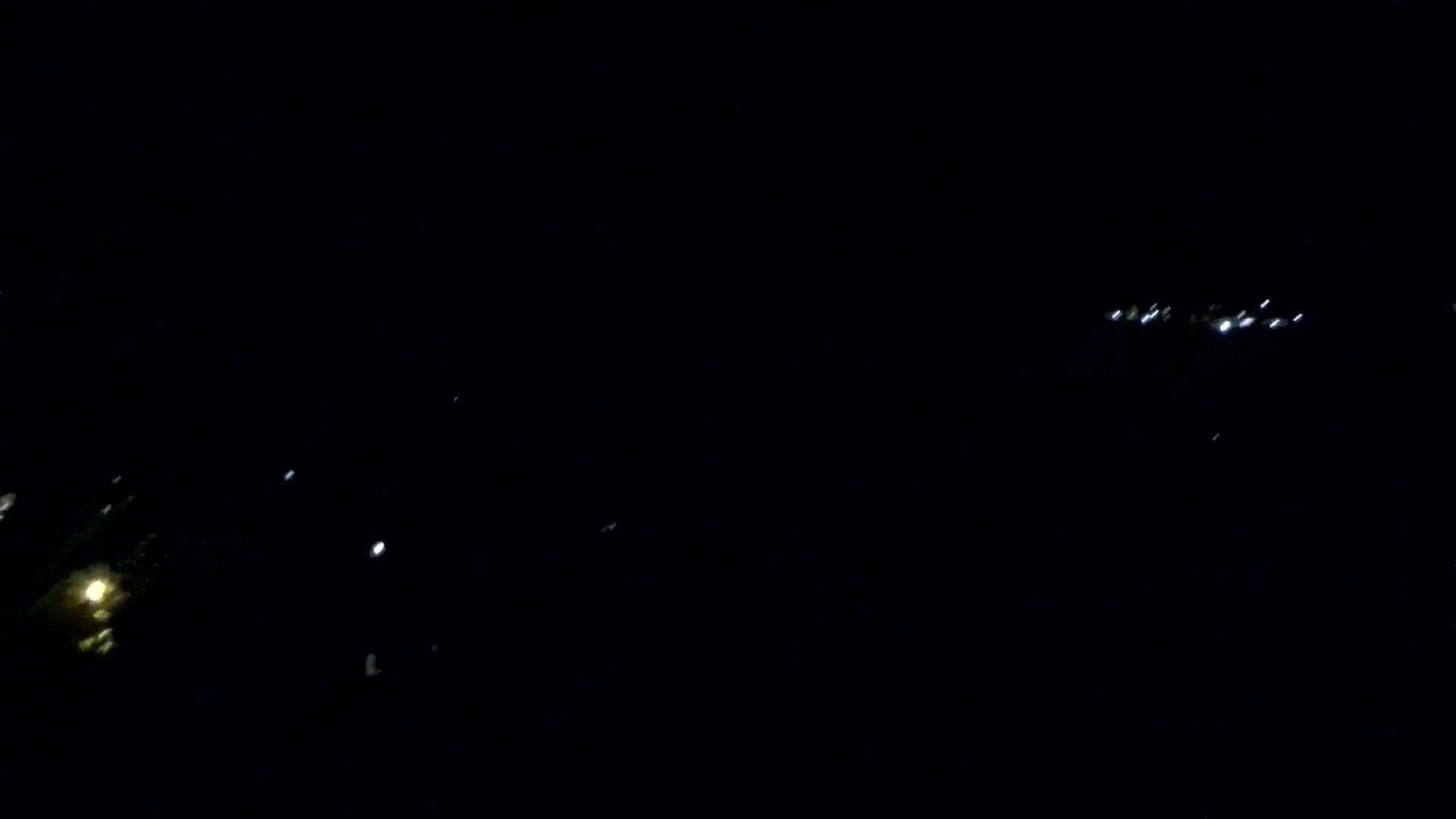 Faint lights from a distance are visible in the dark night sky.