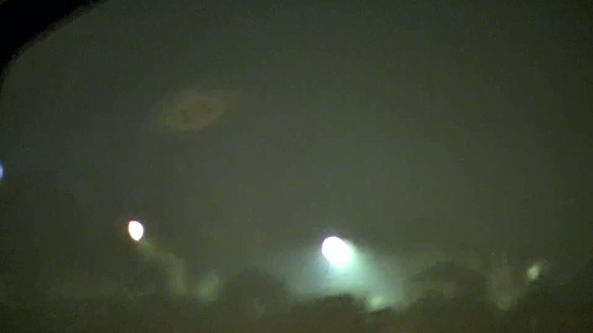 Bright lights illuminate a hazy, dark nighttime scene.