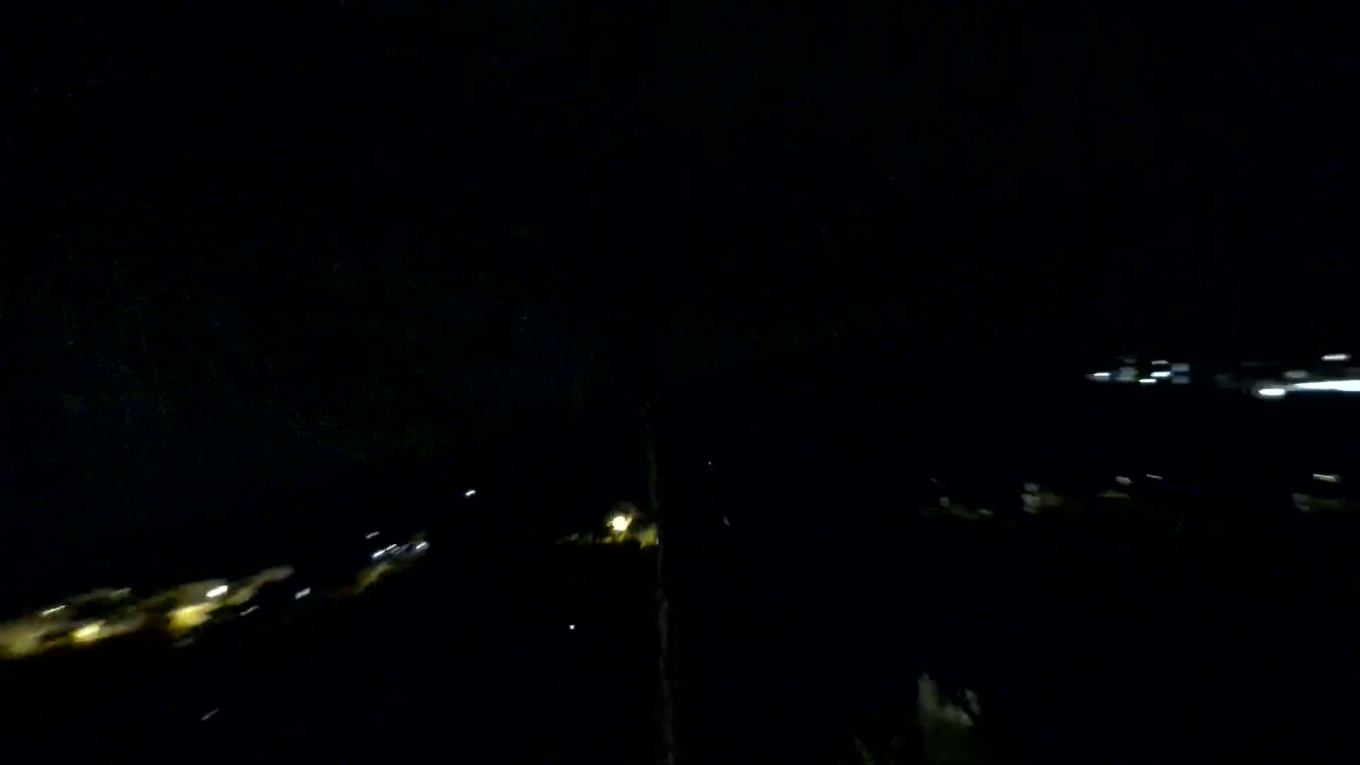 Blurred lights from a distance are visible at night.