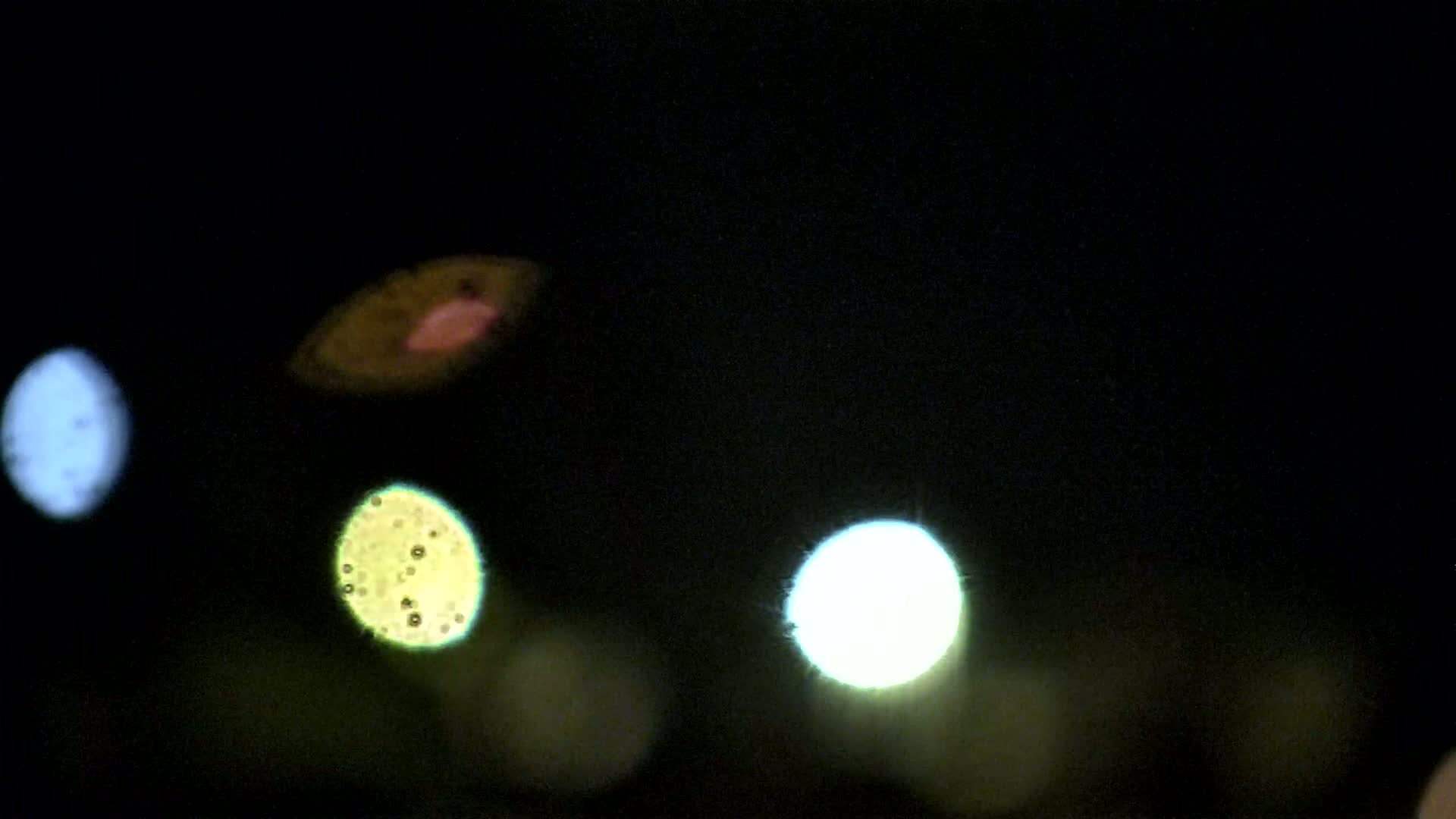 Blurred multicolored lights are visible at night.