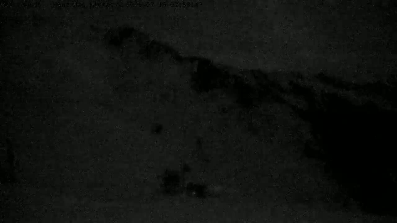 A dark, grainy image shows a faint, lighter area that resembles a mountain range under a night sky.