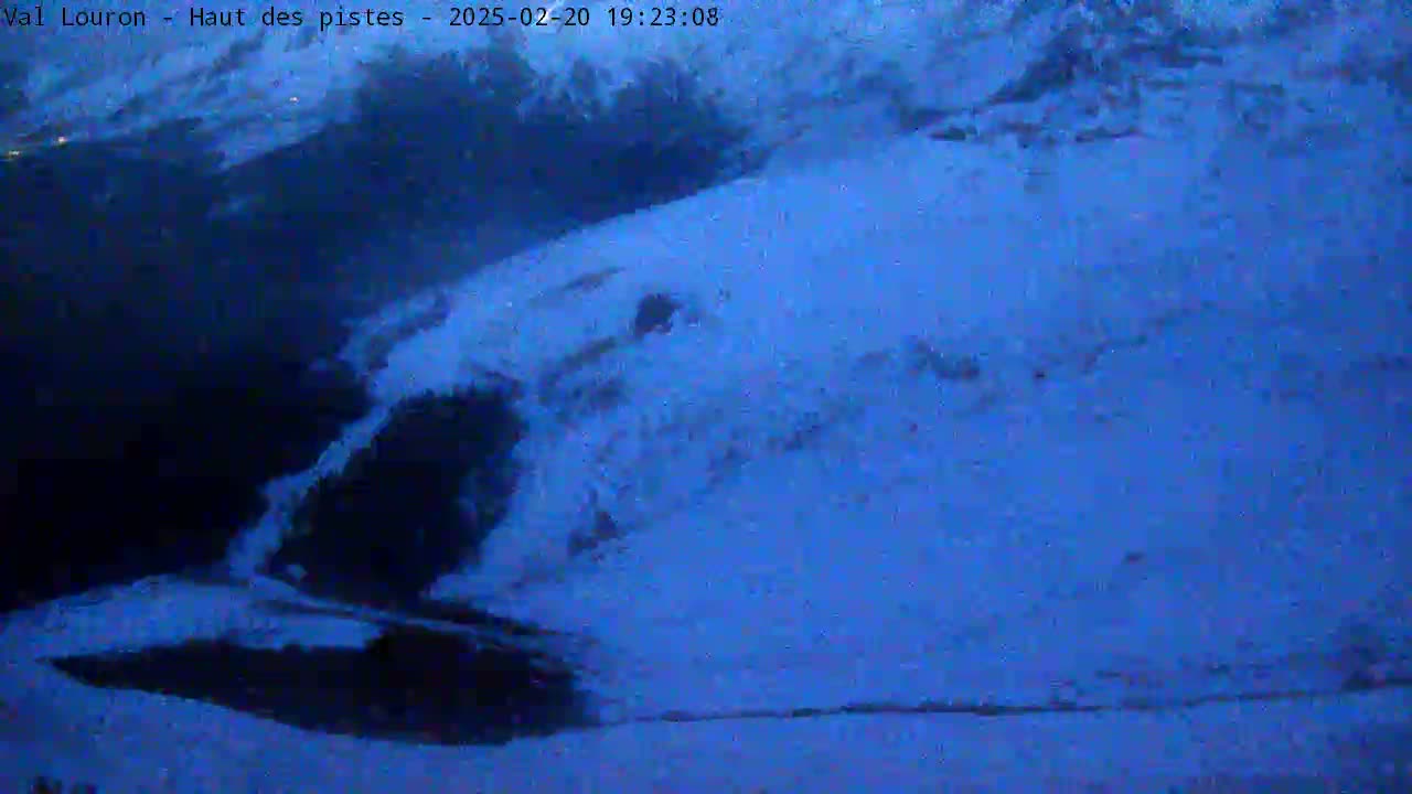 A snow-covered landscape is visible at night under a dark, cloudy sky.