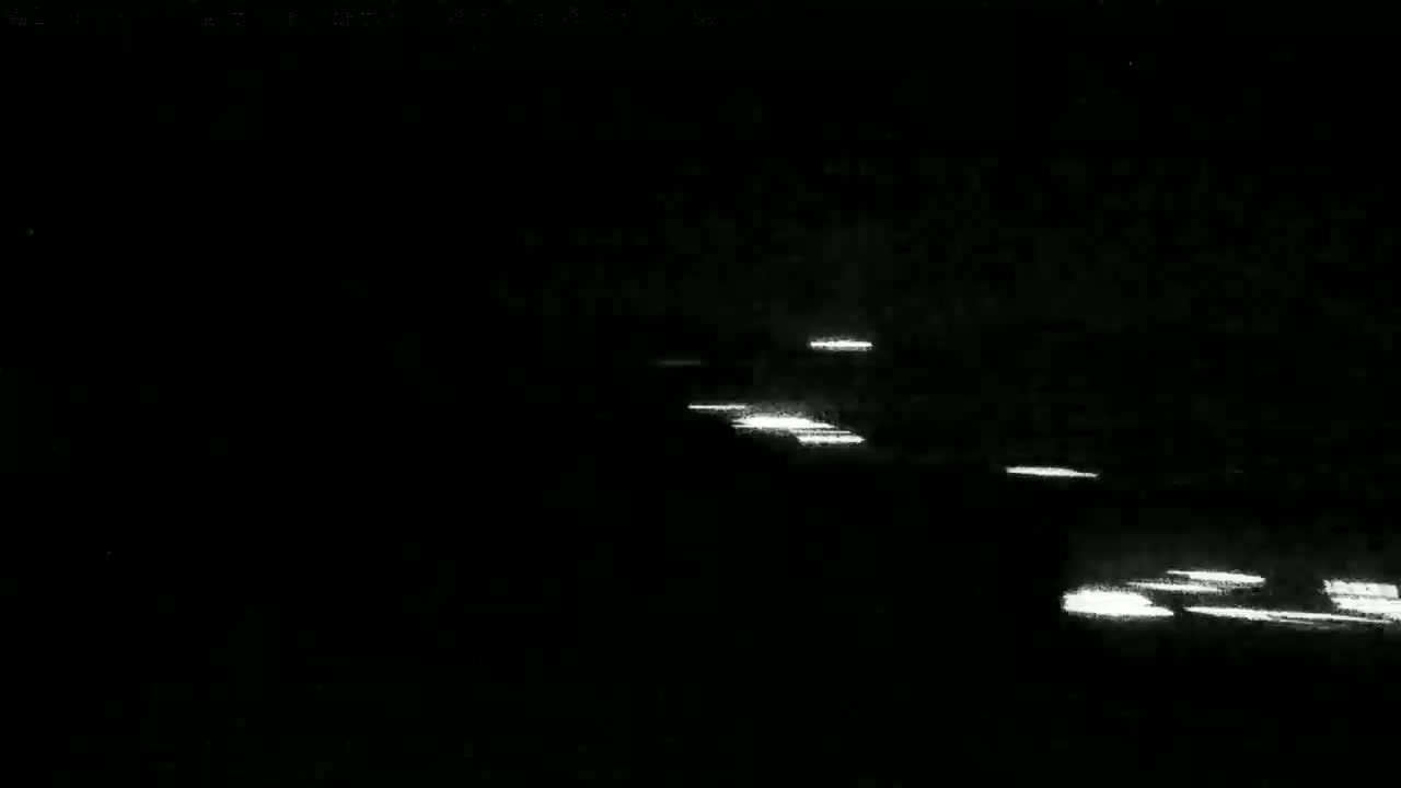 Streaks of white light from vehicle headlights are visible in the darkness of night.