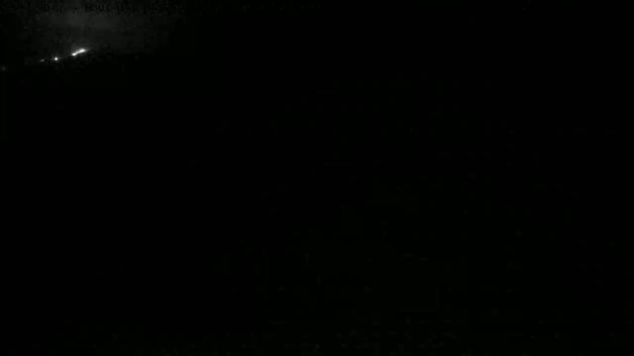 A nighttime, mostly dark scene shows a faint, bright streak in the upper left corner of the frame, possibly a meteor or aircraft.