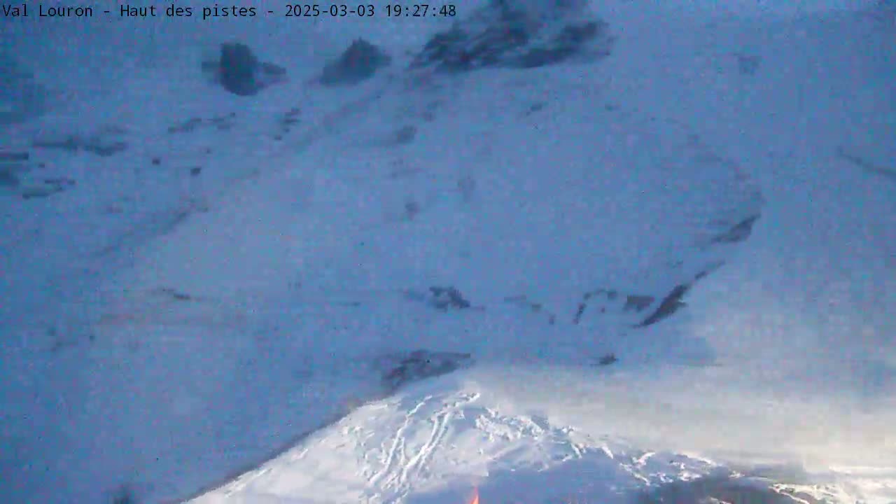 A snow-covered mountain slope is visible under a twilight sky.
