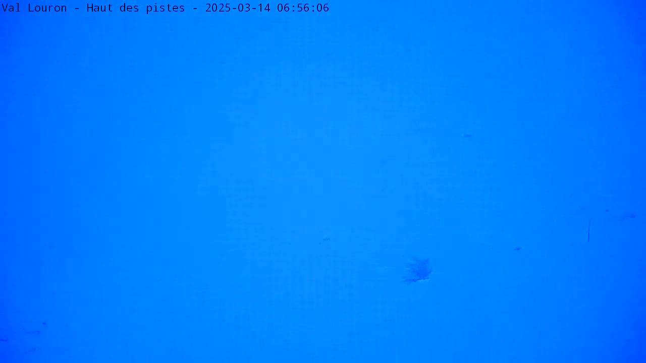 A mostly clear, bright blue sky is visible with a few small, indistinct dark shapes.