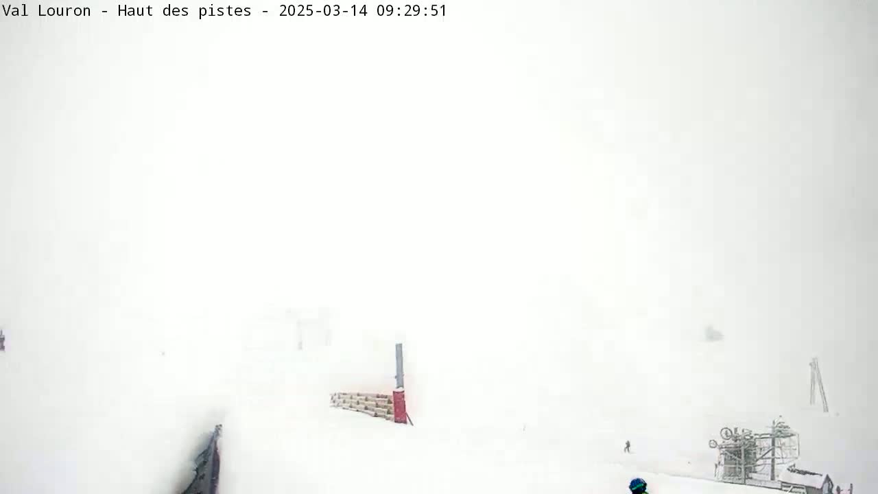 A snow-covered ski slope is barely visible through a heavy snowstorm.