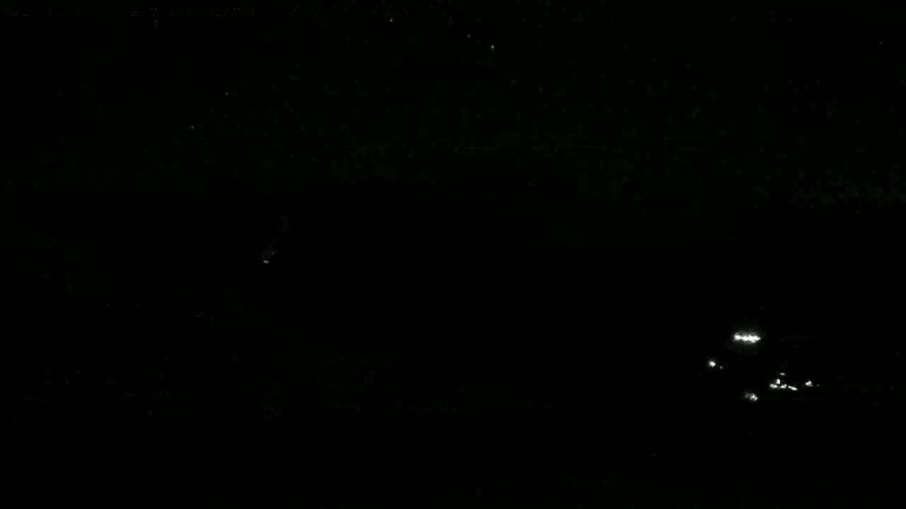 Faint, scattered lights are visible on a dark, nighttime body of water.