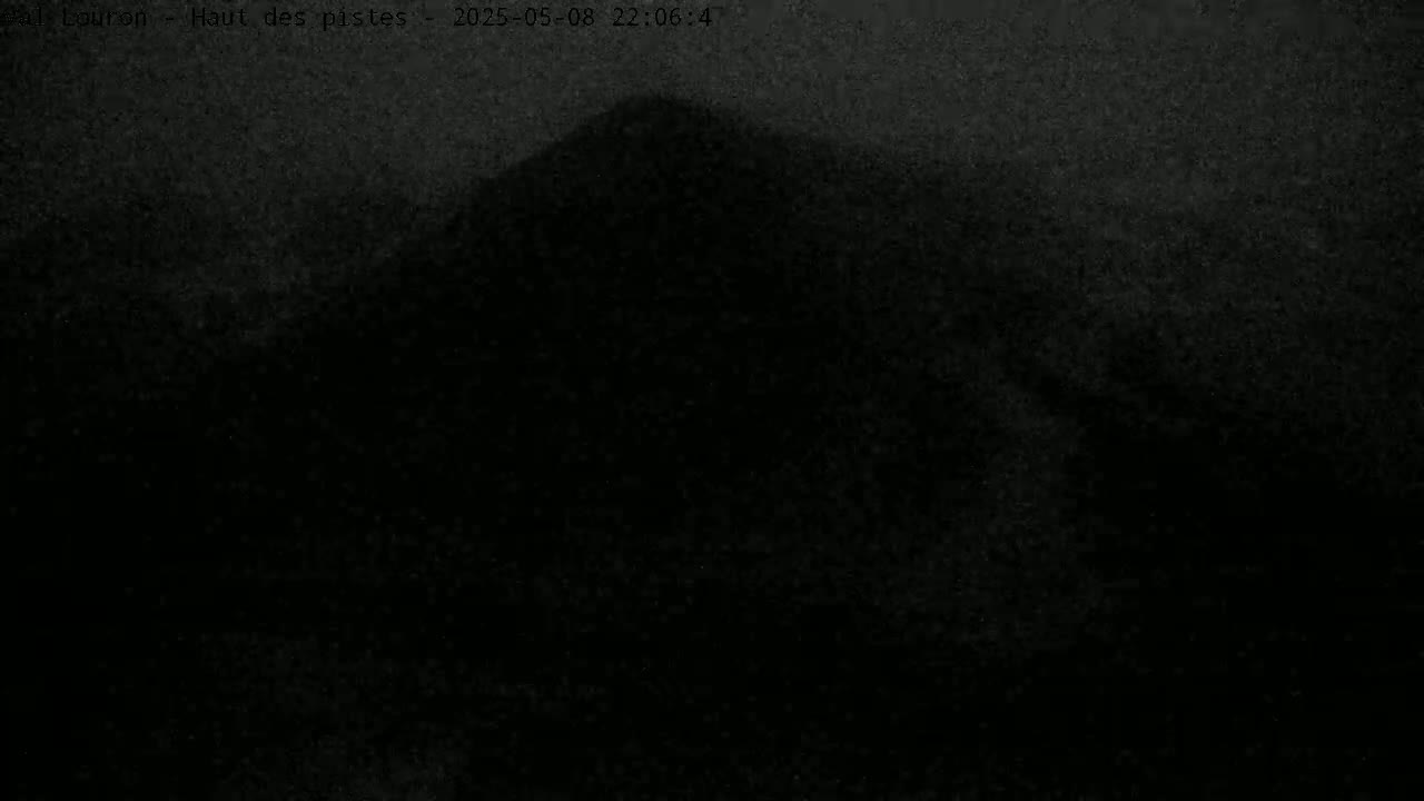 A dark, blurry image shows a hill or mountain under a night sky.