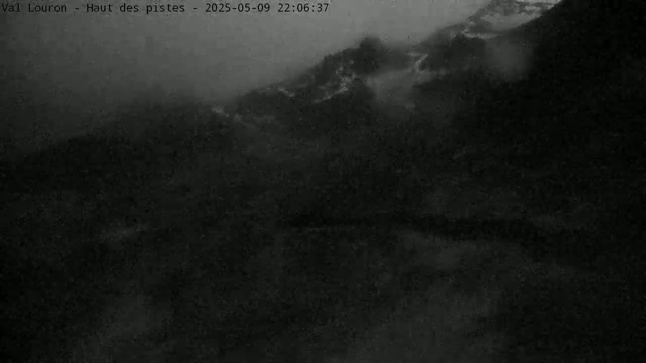 A dark, foggy, nighttime landscape shows indistinct hills and valleys.