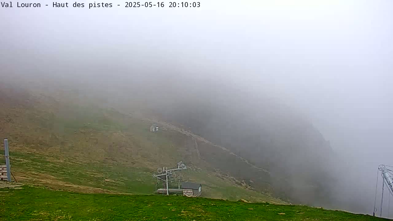 A foggy, hilly landscape with a ski lift and small building is visible.