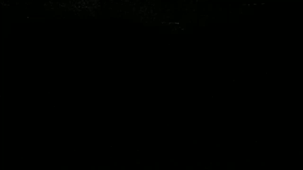 The image is almost entirely black, with a few faint, barely visible specks of light.