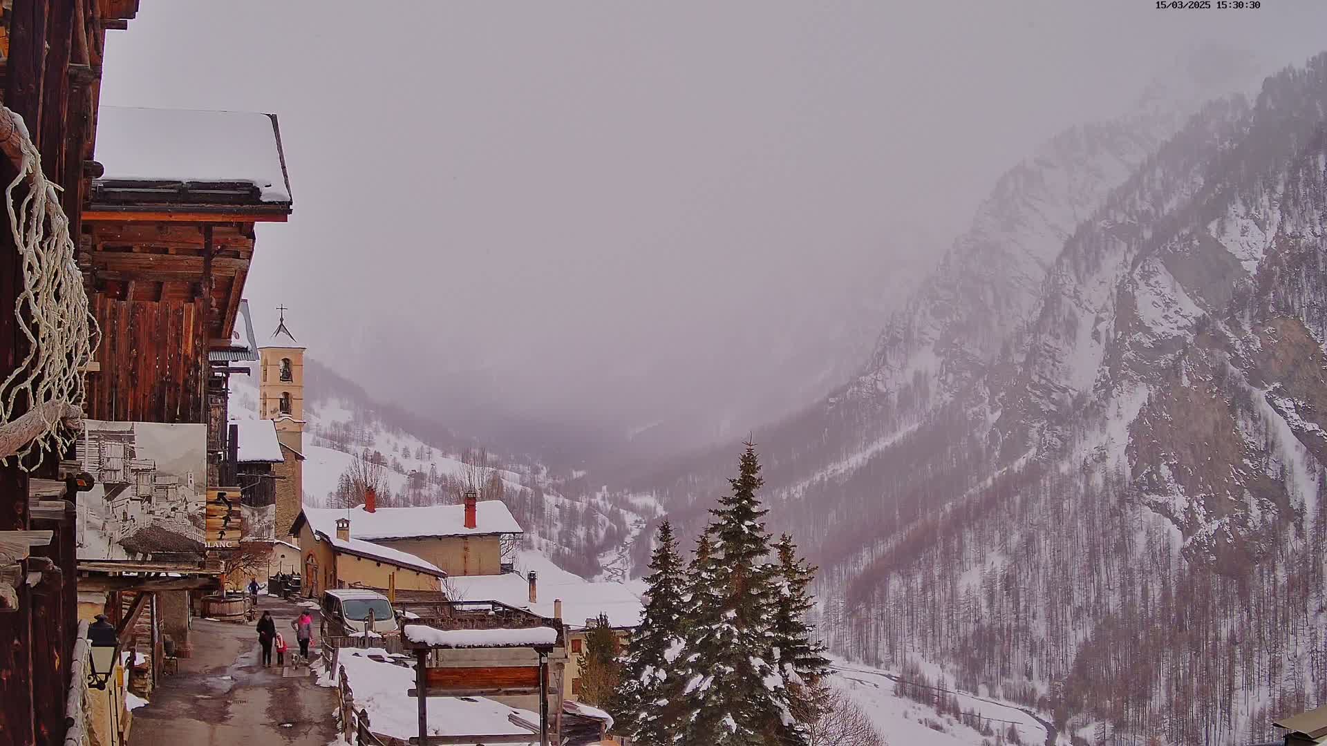 A snow-covered village nestled in a valley between misty mountains.