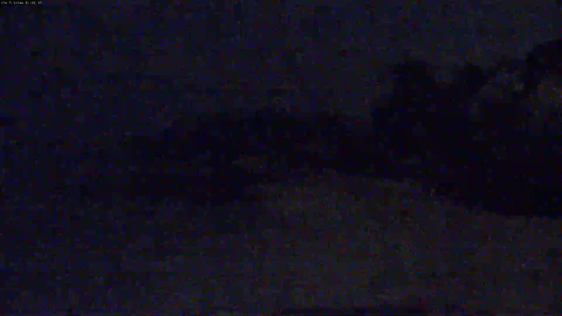 A dark, blurry image shows a mostly indistinct landscape at night.