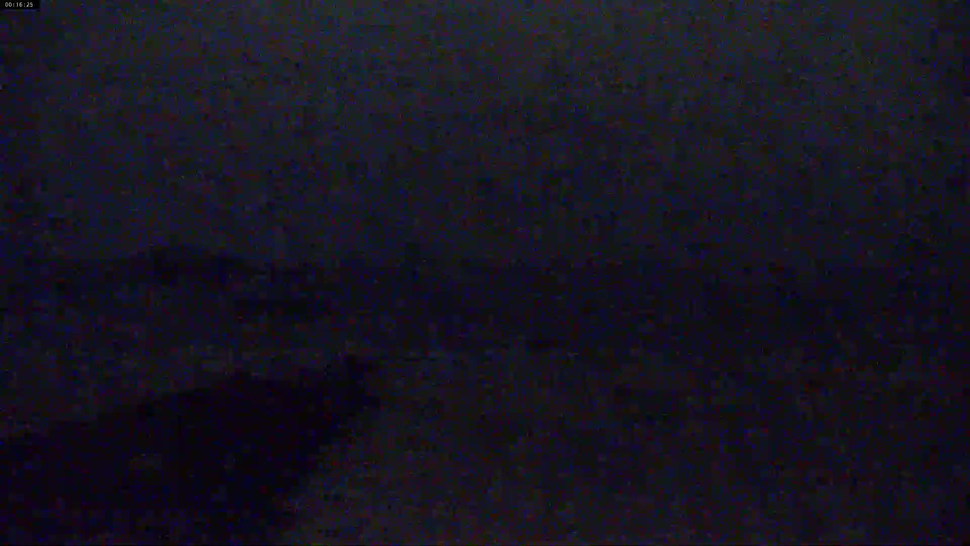 A dark, grainy image shows an indistinguishable scene at night.
