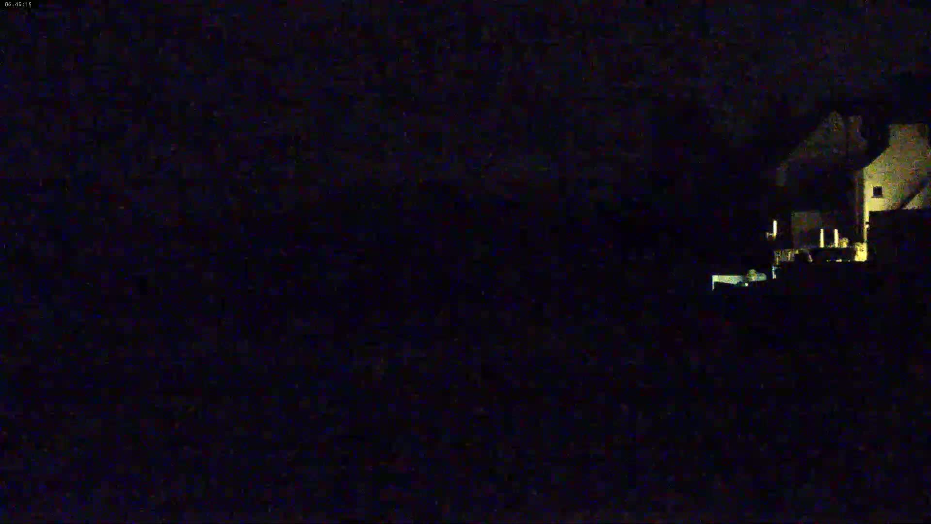 A dimly lit building is visible at night in low-light conditions.