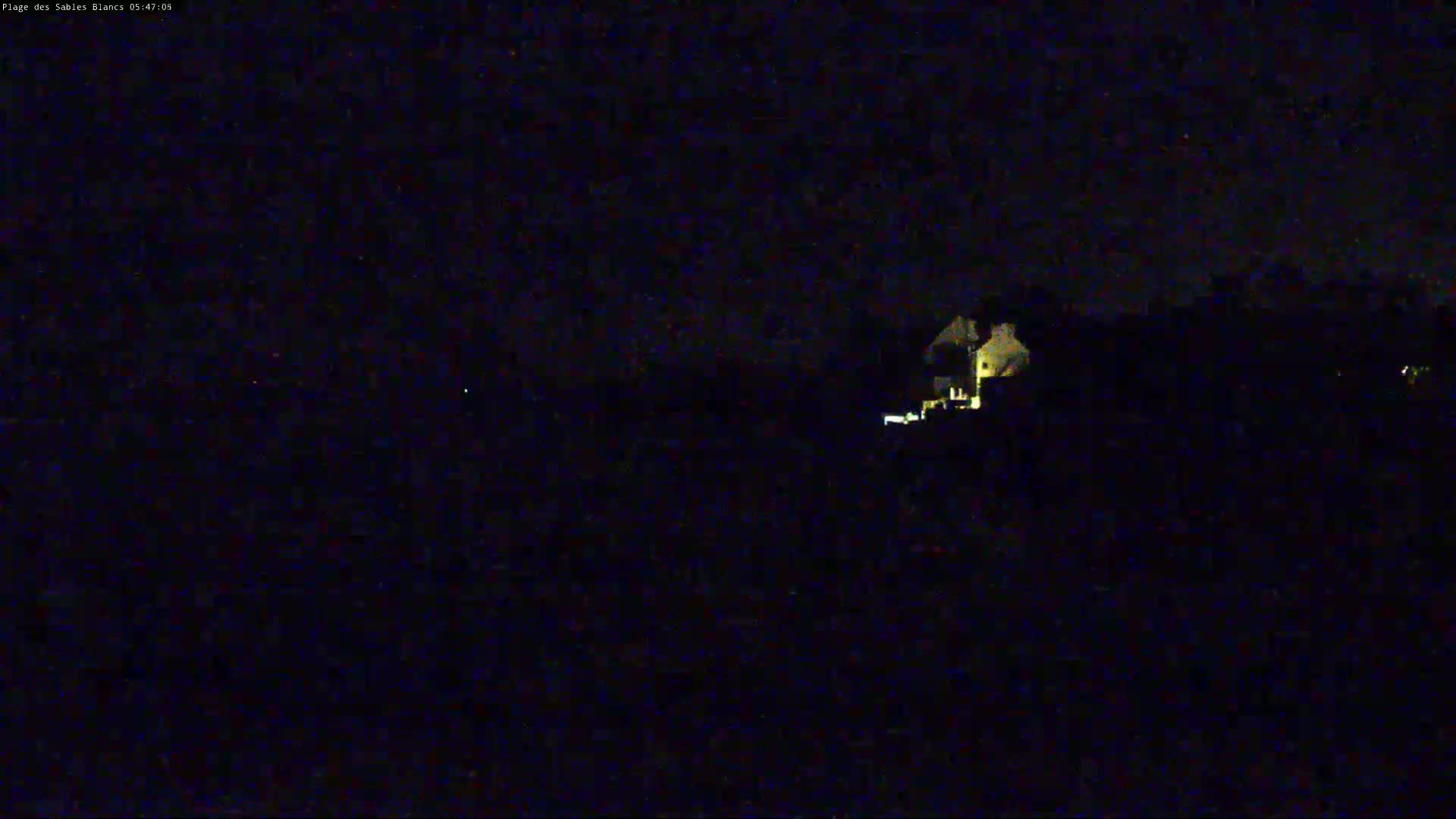 A dimly lit building is visible in the distance under a dark, nighttime sky.