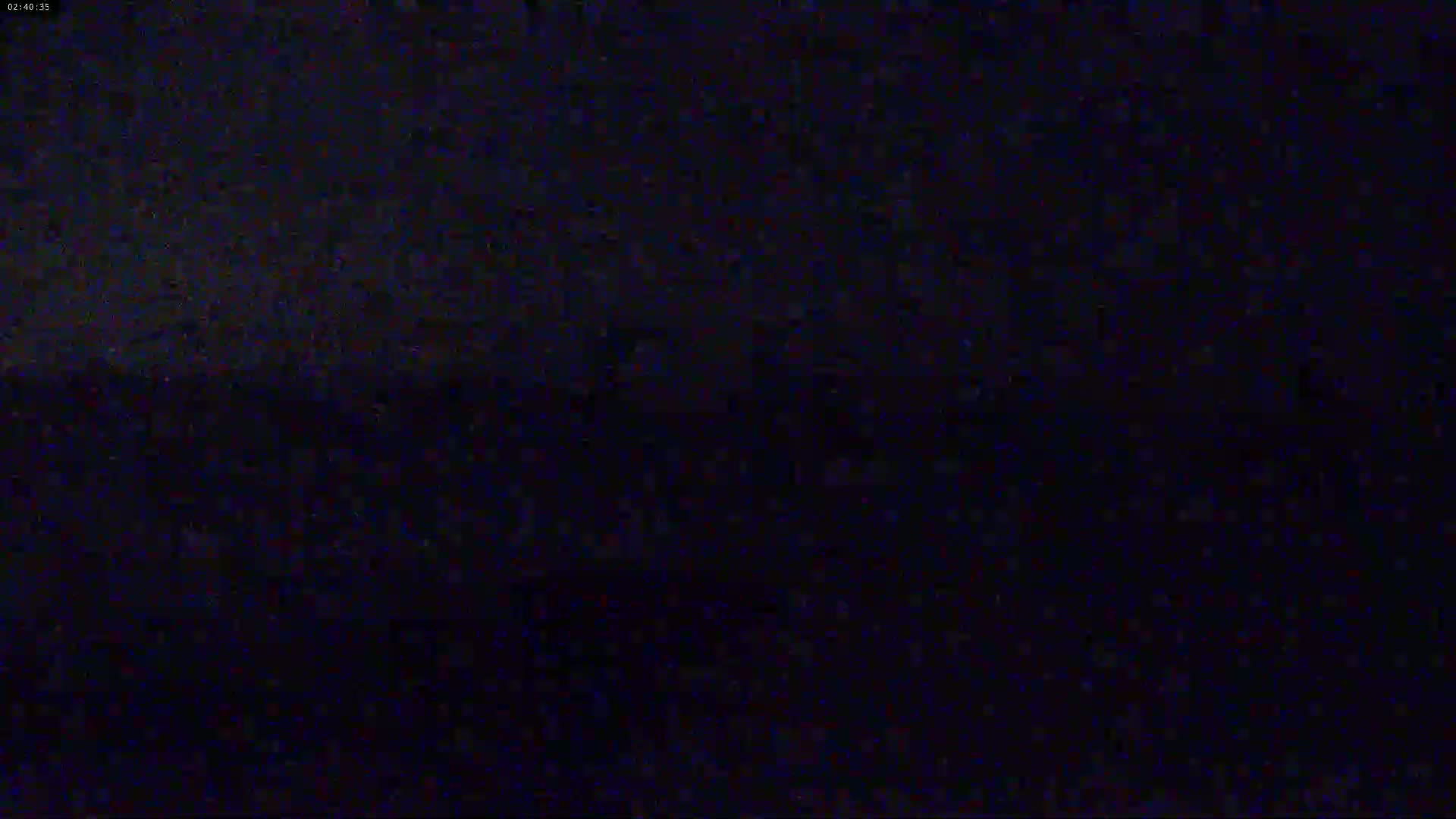 A dark, nighttime scene is shown with a slightly lighter horizon line.