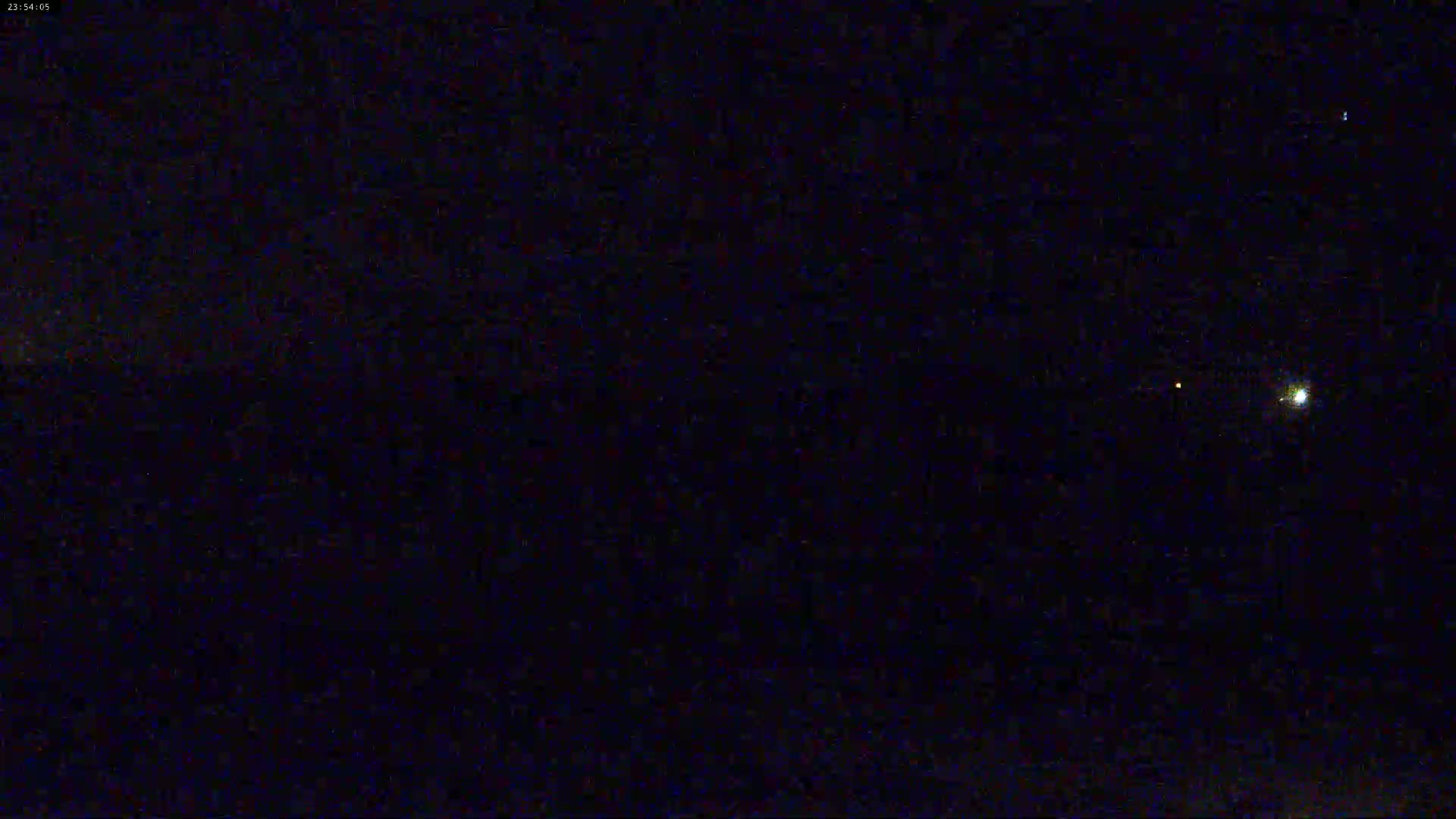 A nighttime, dark sky shows a few faint stars and a brighter light, possibly a planet or a very bright star.