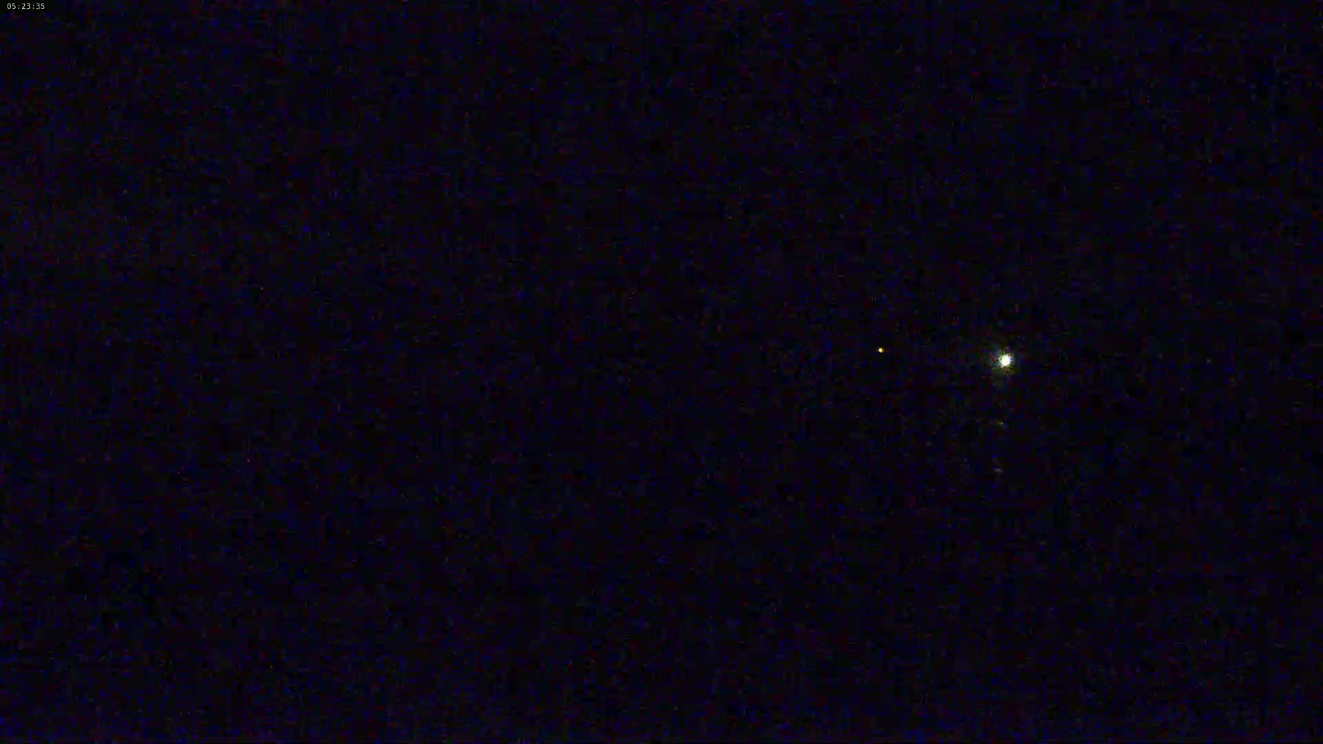A dark night sky shows a bright star and two fainter points of light.