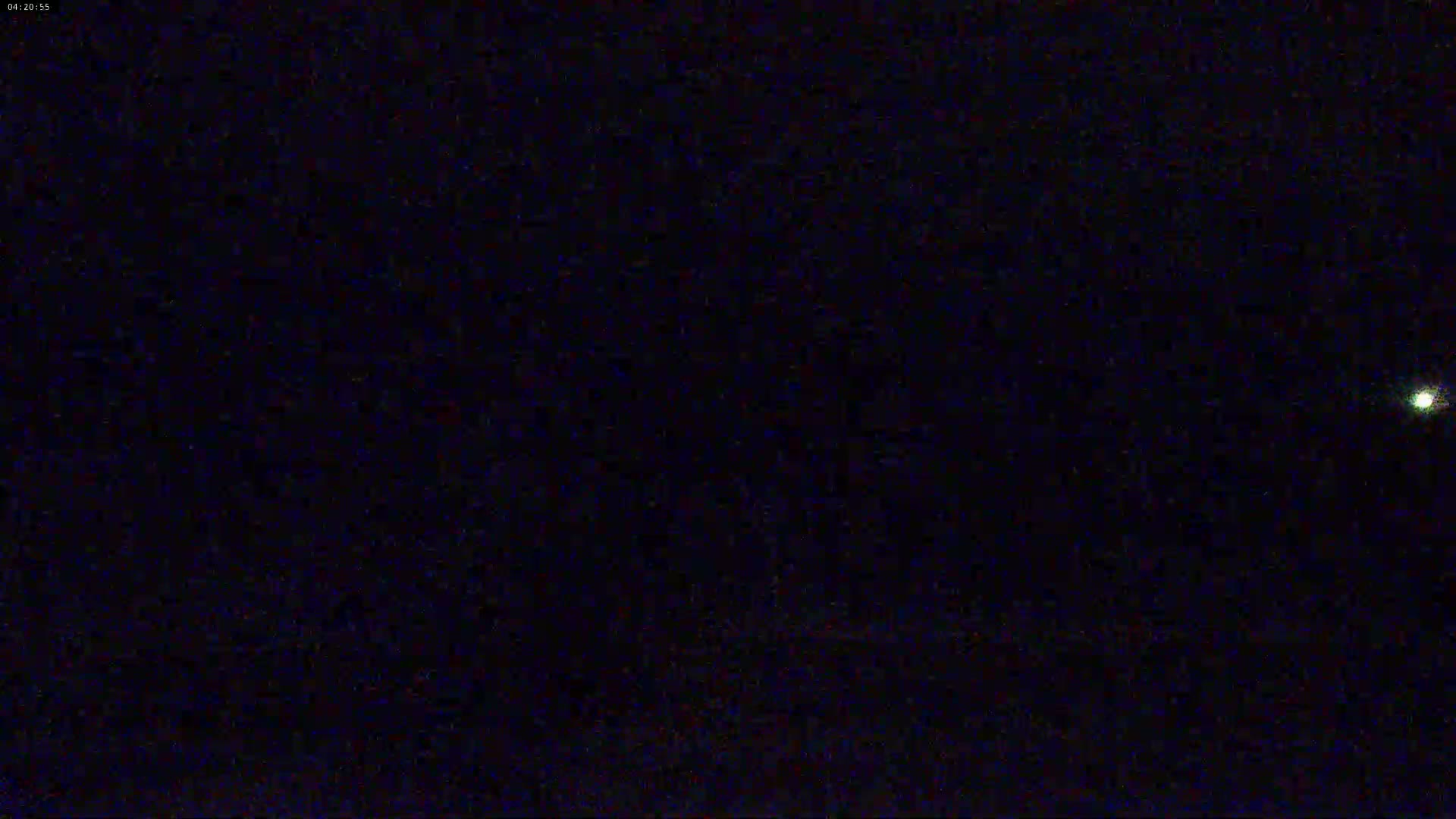 A nighttime image shows a single, bright light in a dark sky.