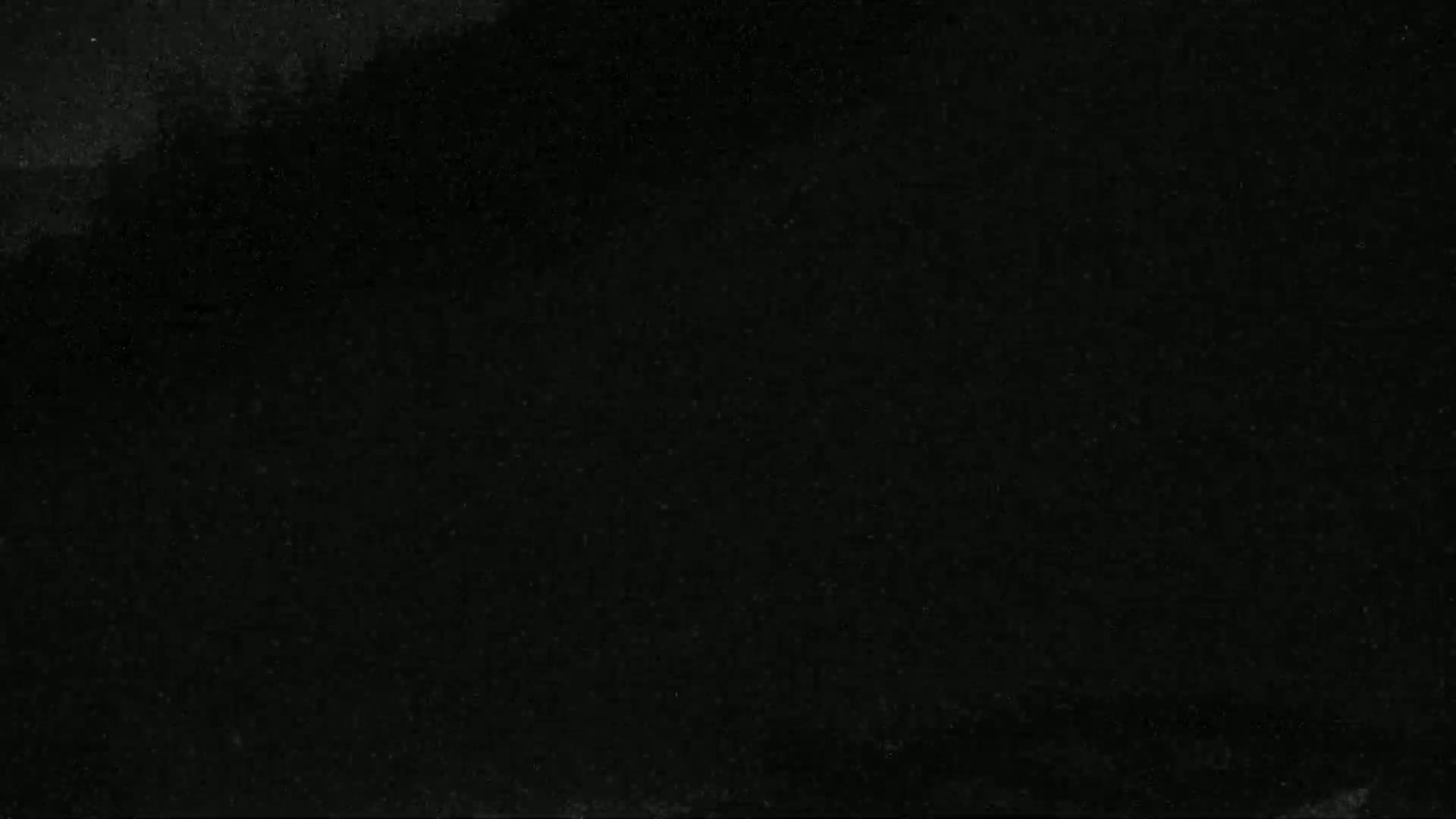 The image shows a dark, possibly black, textured surface with subtle variations in shading.